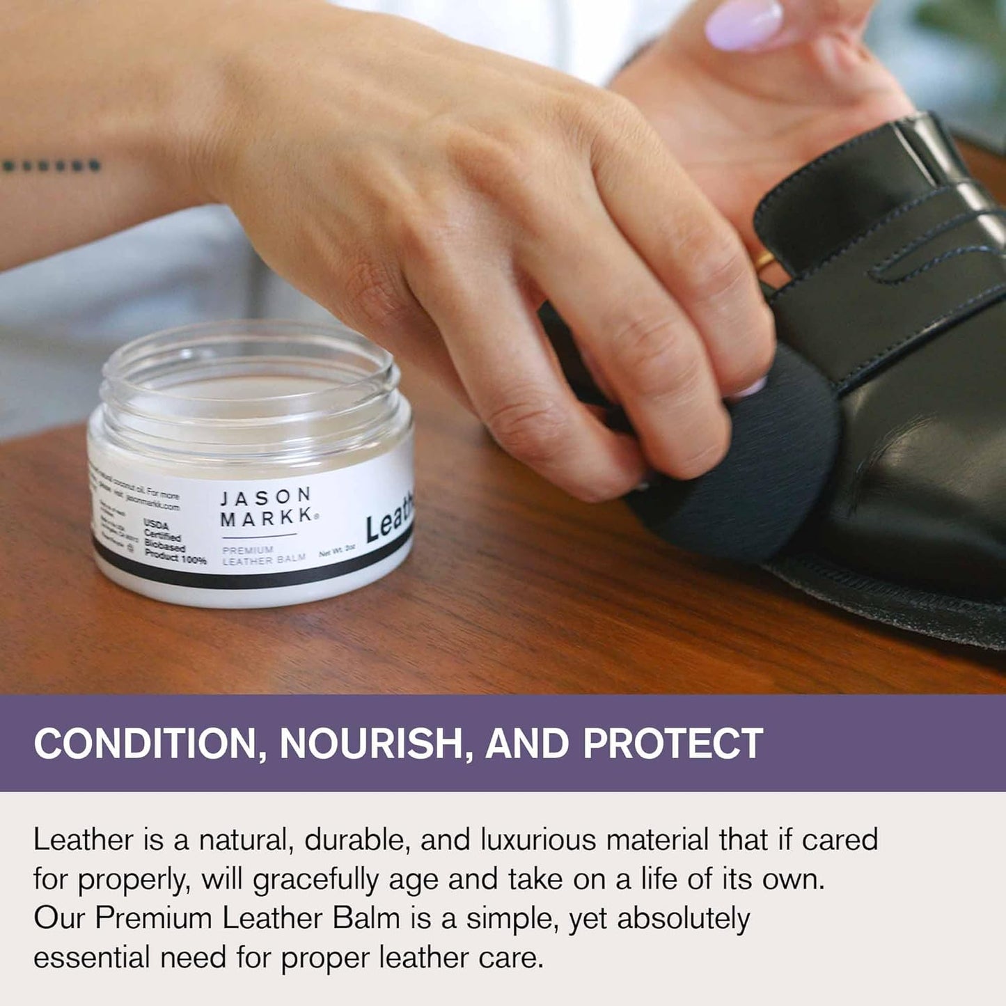 Person applying leather balm to a black shoe with a jar of Jason Markk leather balm on a wooden surface.